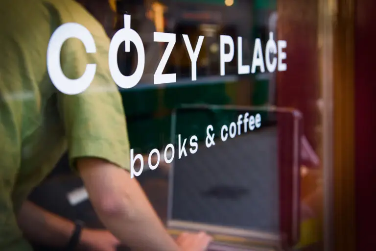 Man inside Cozy Place books and coffee through fron window