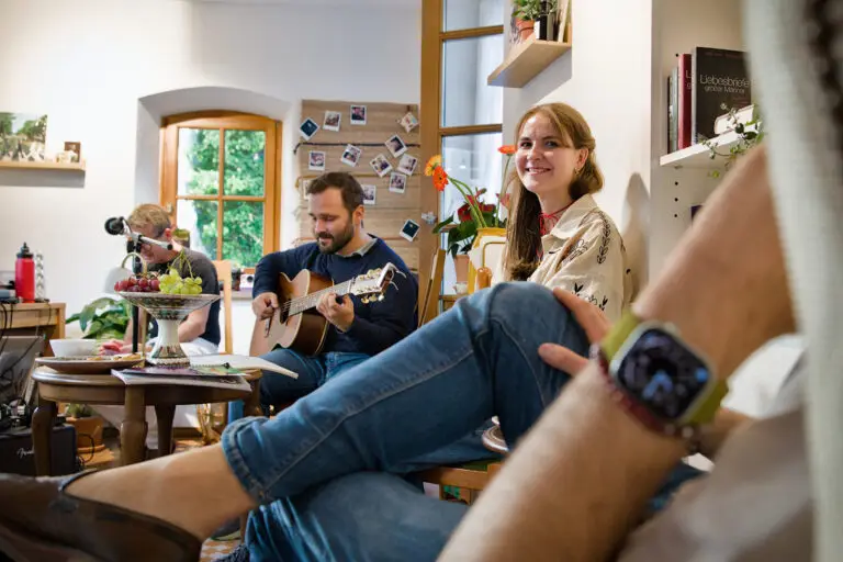 Guitar player in the background with people relaxing