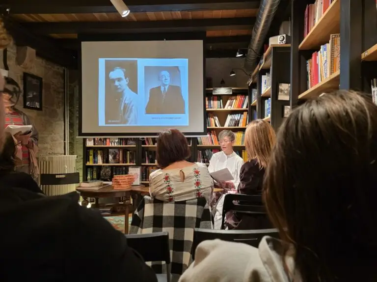 Presenter speaking about Ukrainian Avant-garde art in front of an interested audience at Cozy Place, while presenting slides